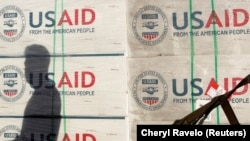 Silueta e një personi pranë pakove me ndihma nga USAID. Fotografi nga arkivi.
