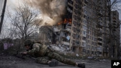 Ukrajinske trupe u Avdijevki sada se navodno bore protiv ruskih snaga unutar samog grada. (Foto: Ukrajinski vojnik u zaklonu ispred zapaljene zgrade koja je pogođena u ruskom vazdušnom napadu u Avdijevki, Ukrajina, u petak, 17. marta 2023.)