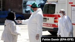 Medicinski radnici proveravaju temperaturu pacijentkinji ispred bolnice u Sarajevu, 9. aprila 2020. 