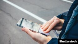 Një person duke pastruar telefonin. 