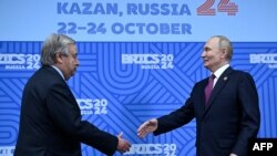Secretarul general al ONU, Antonio Guterres, dă mâna cu președintele rus Vladimir Putin la summitul de la Kazan, 24 octombrie. 