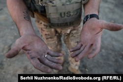 Mâinile veteranului genist ucrainean Andrii, cunoscut și sub numele de „Porthos”