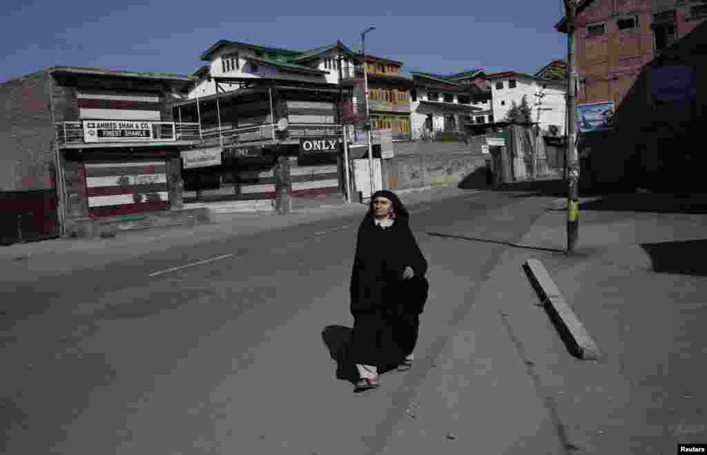 Një grua nga Kashmiri ecë në rrugët e boshatisura. 